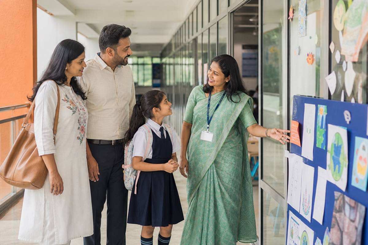 Indian parents speaking with a teacher during a CBSE campus visit