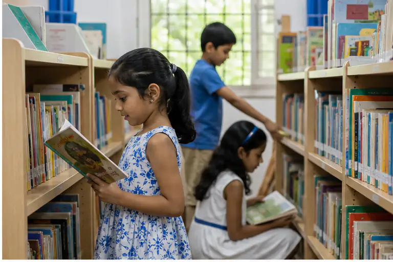 Children choose interesting age-appropriate books in a school library